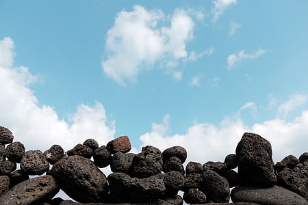 black rock formation under white clouds at daytime thumbnail