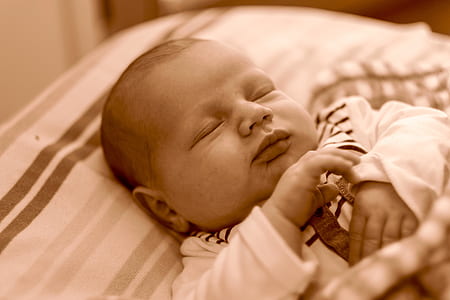 baby sleeping on striped linen inside room thumbnail
