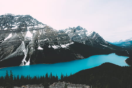 lake between mountains and trees during daytime thumbnail