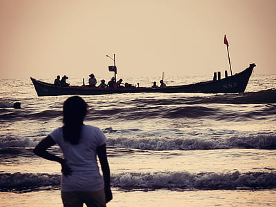 photo of girl looking towards boat on body of water thumbnail