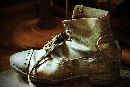 close up photography of unpaired brown leather boots thumbnail