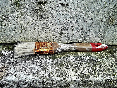 brown and red handled paintbrush on grey concrete shelf thumbnail