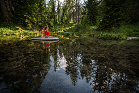 woman doing yoga on gray platform surrounded by water thumbnail