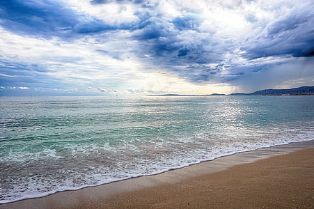landscape photography of seashore under cumulus clouds thumbnail