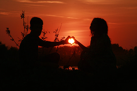 silhouette of two person making heart hand sign thumbnail