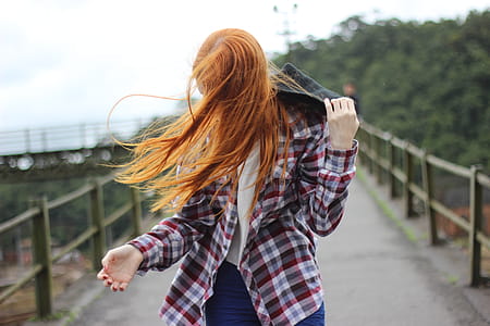 Woman Wearing Plaid Button-up Sport Shirt While Holding Black Hood thumbnail