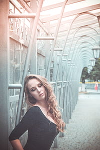 woman leaning on metal post thumbnail