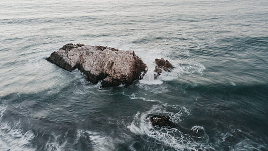 rock formation surrounded by ocean water thumbnail