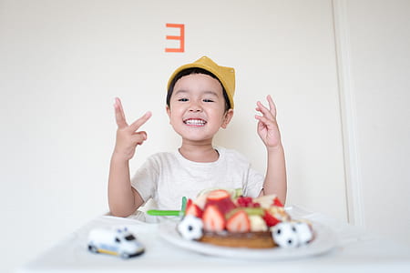 boy sitting on white highchair with strawberry dish on tray thumbnail