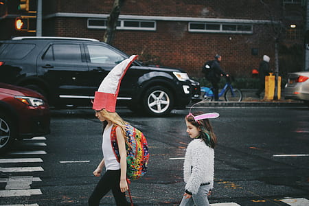 two girls walking near road during daytime thumbnail