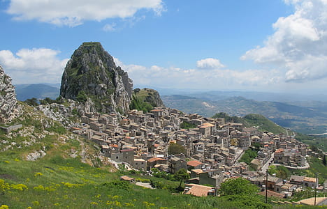 gray concrete houses near mountain during daytime thumbnail