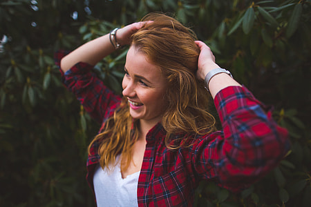 smiling woman standing beside green leafed plant thumbnail