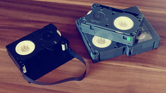 Betamax Tapes on Top of Brown Wooden Surface thumbnail