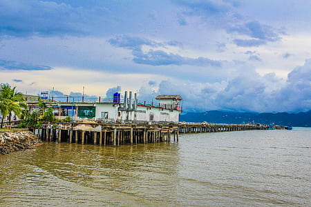 White Concrete Building Beside Body of Water Under Blue and White Sky at Daytime thumbnail