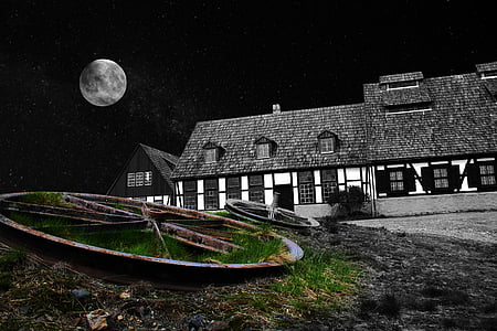selective color photo of wagon wheels in front of house during night of full moon thumbnail
