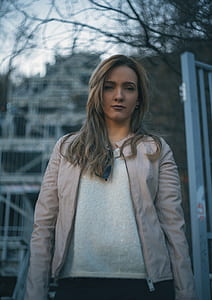 selective focus photo of woman standing near gate thumbnail
