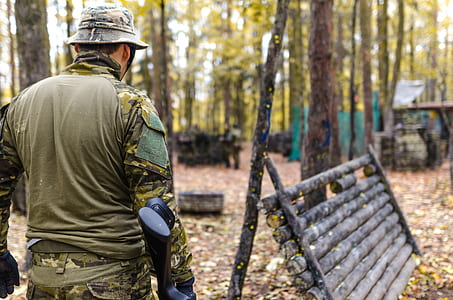 Selective Focus Photography of Man Wearing Camoflouge Suit While Holding a Gun thumbnail