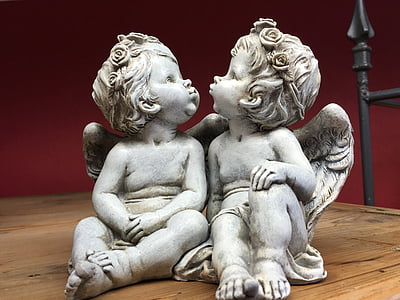 two cherub kissing each other concrete statuette on wooden surface thumbnail