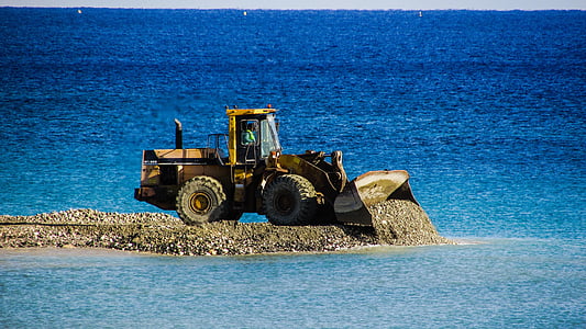 photo of yellow front-end loader near body of water thumbnail