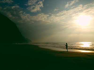 silhouette of person standing on beach sand thumbnail