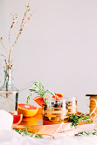 two clear shot glasses beside orange fruits thumbnail