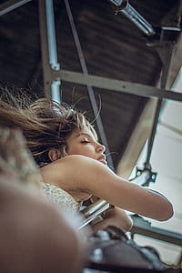 woman in white top holding grey steel rod thumbnail