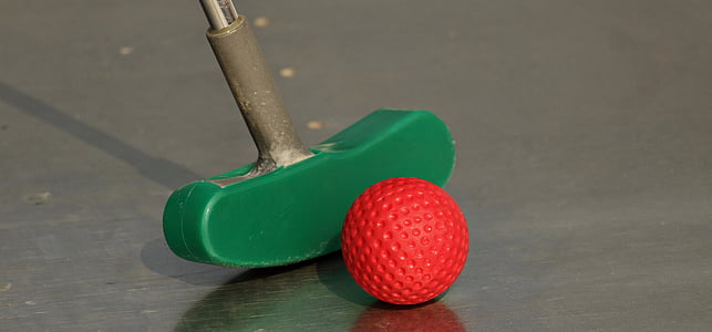 close-up photography of red golf ball and green golf putter thumbnail