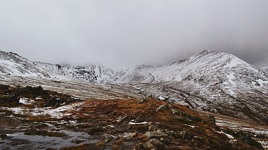 photo of snow covered mountain under grey sky thumbnail