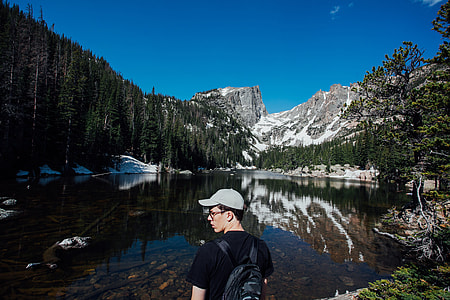 man in black t-shirt and gray cap near body of water thumbnail