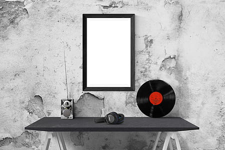black wireless headphones on table with vinyl disc and mirror on wall thumbnail