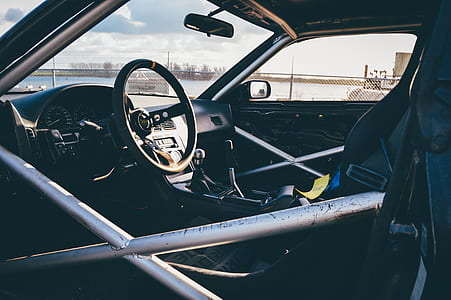 closeup photography of vehicle interior with roll cage during daytime thumbnail