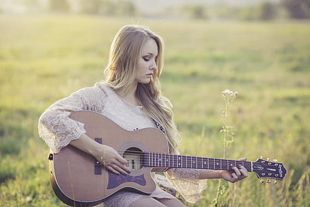 Woman Playing Brown Wooden Acoustic Guitar during Daytime thumbnail