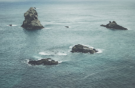 black and gray big rock surrounded by body of water at daytime thumbnail