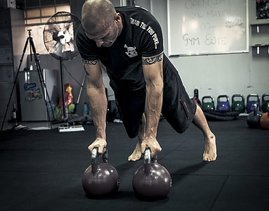 man exercising using kettle bells thumbnail