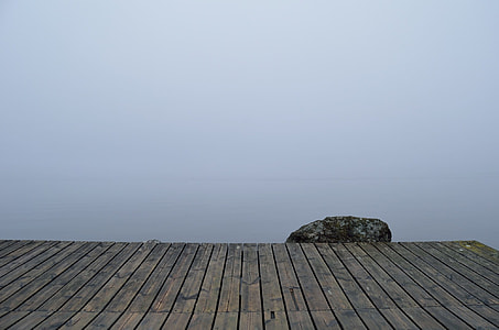 gray rock near brown wooden deck during foggy day thumbnail