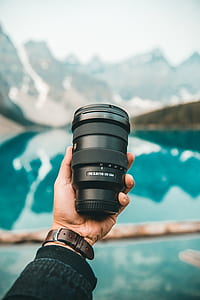 person holding a black camera lens thumbnail