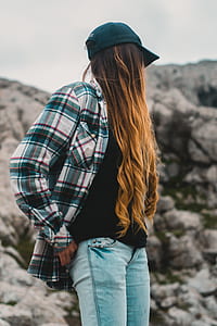 selective focus of woman standing near rock formation during daytime thumbnail