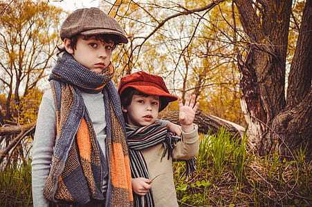 two boys standing near trees thumbnail