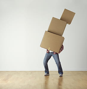 person wearing red shirt carrying three brown boxes thumbnail