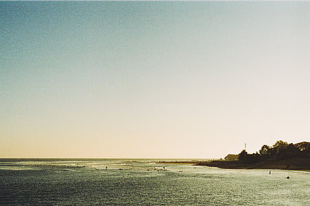 blue ocean near island under clear blue sky thumbnail