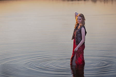 standing woman in water wearing red dress thumbnail