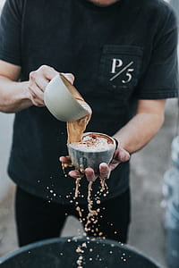 man holding gray ceramic cups thumbnail