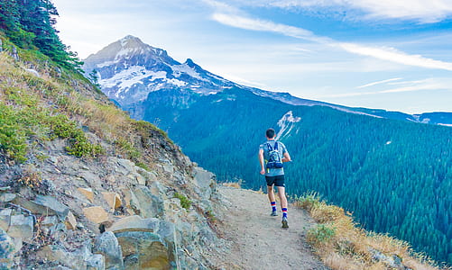 man running on cliff under clear blue sky thumbnail