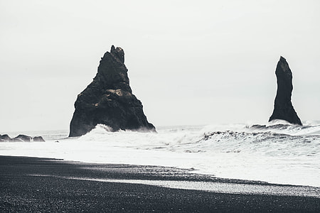 black rock formation on body of water thumbnail