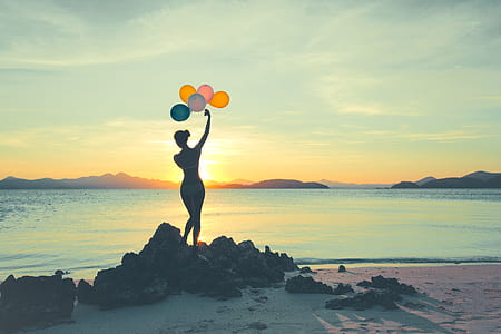 silhouette of woman holding balloons thumbnail