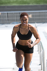 Woman Wearing Black Sports Bra and Jogger Shorts Smiling thumbnail