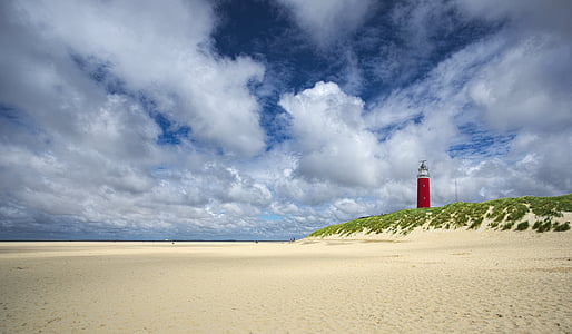 in distant photo of red lighthouse on landscape beach thumbnail