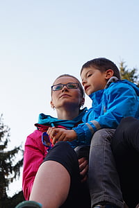 boy in blue jacket sitting on woman's lap thumbnail