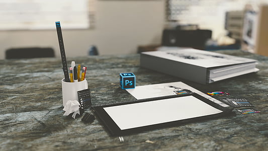 white ceramic mug near white printer paper and grey binders thumbnail
