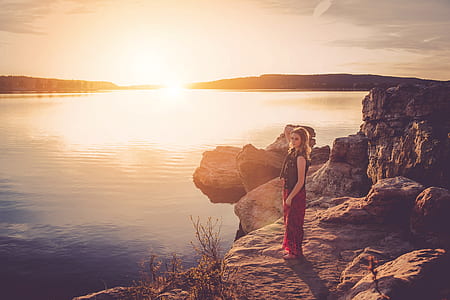 woman standing on brown edge of rock thumbnail